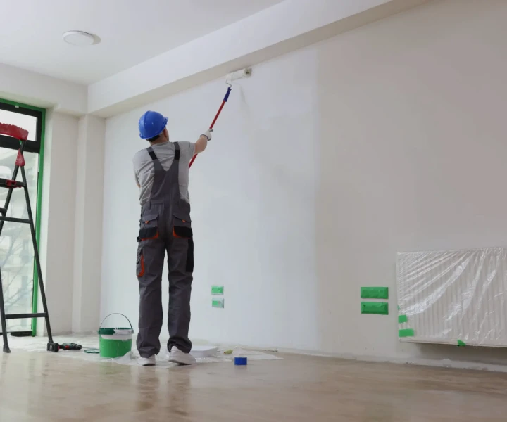 Person using roller to paint wall